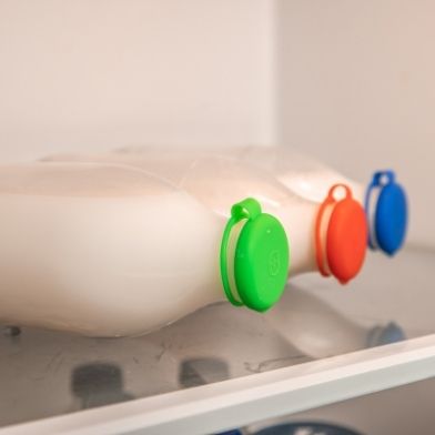 Milk Topz caps on milk bottles lying on their side in a fridge